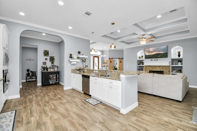 kitchen with white cabinets, appliances with stainless steel finishes, hanging light fixtures, and light hardwood / wood-style flooring