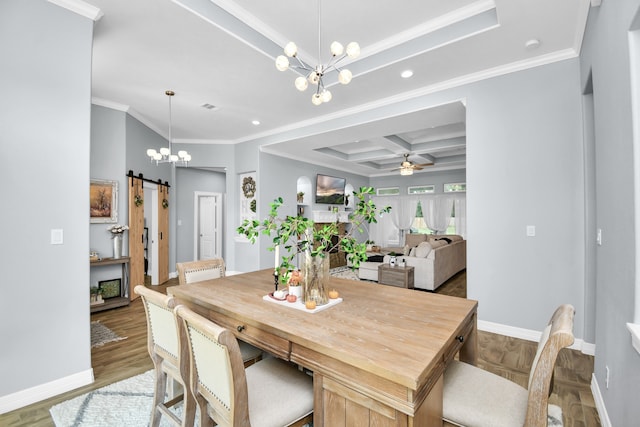 dining area featuring ornamental molding, wood-type flooring, coffered ceiling, ceiling fan with notable chandelier, and a barn door