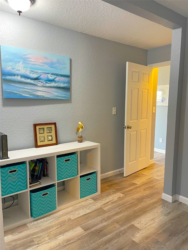 recreation room featuring hardwood / wood-style floors and a textured ceiling