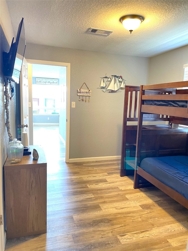 bedroom with wood-type flooring and a textured ceiling