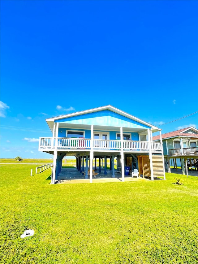 rear view of property featuring a wooden deck and a yard