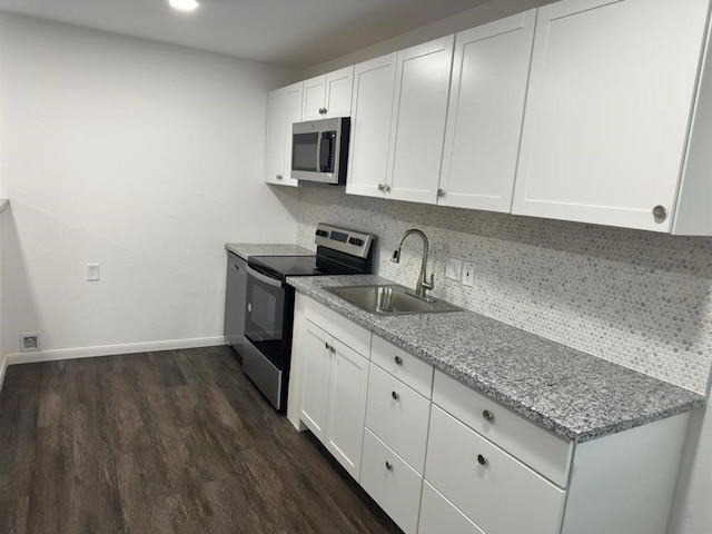 kitchen featuring stainless steel appliances, dark hardwood / wood-style flooring, light stone countertops, sink, and white cabinets