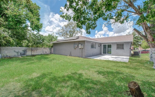 rear view of house featuring a lawn and a patio area