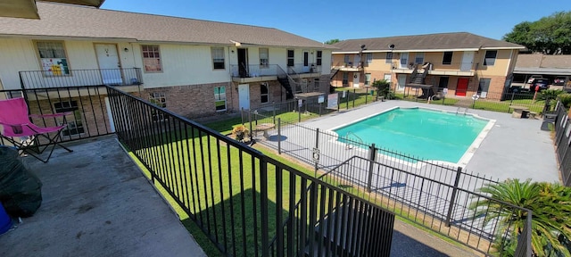 view of pool with a patio and a yard