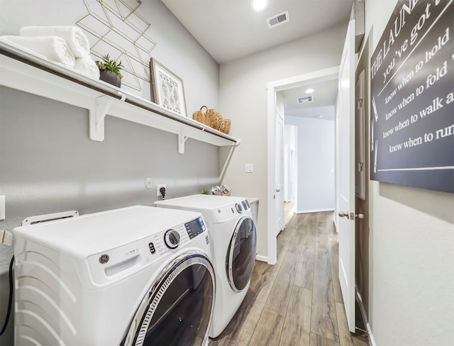 laundry area with washing machine and dryer and hardwood / wood-style floors