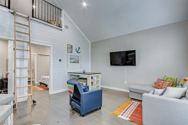 1052 Johnson Rd, Gilchrist, TX 77617 - living area featuring baseboards, light wood-style floors, lofted ceiling, wooden walls, and a barn door
