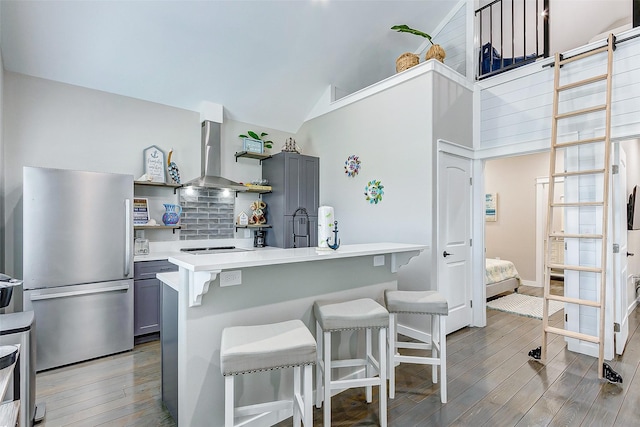 1052 Johnson Rd, Gilchrist, TX 77617 - kitchen featuring freestanding refrigerator, island range hood, gray cabinetry, open shelves, and a kitchen bar