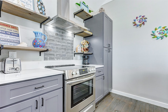 kitchen with gray cabinets, dark wood-type flooring, exhaust hood, and electric range