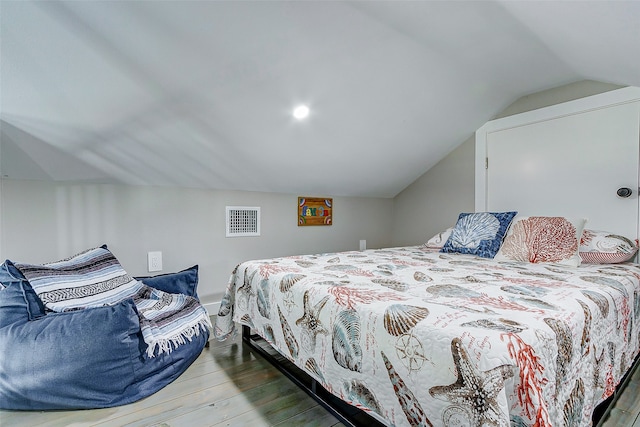 bedroom with lofted ceiling and wood-type flooring