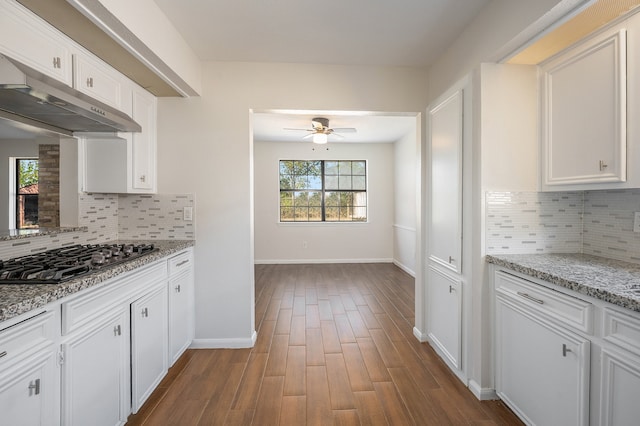 kitchen featuring white cabinets, decorative backsplash, dark hardwood / wood-style flooring, and stainless steel gas cooktop