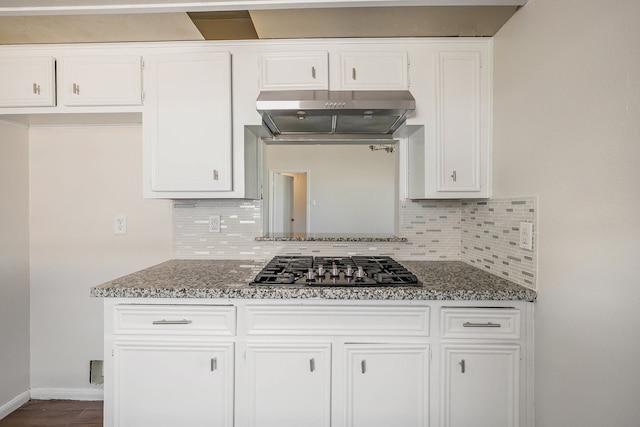 kitchen featuring backsplash, dark stone countertops, white cabinetry, and exhaust hood