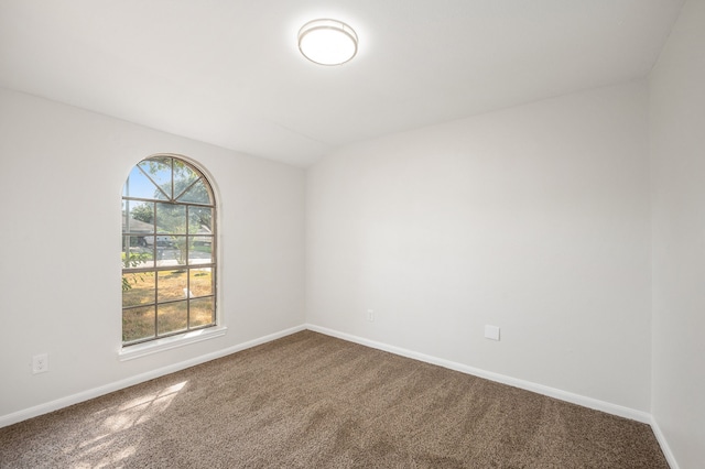 empty room with carpet flooring and vaulted ceiling