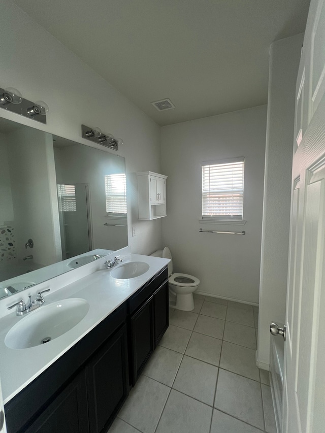 bathroom with toilet, vanity, tile patterned floors, and walk in shower