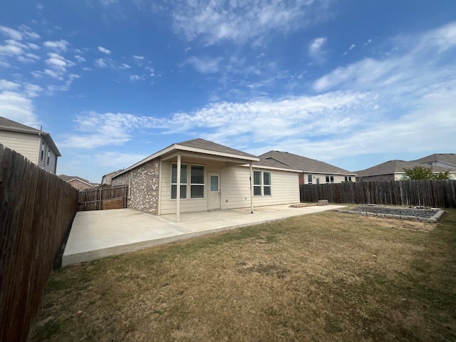 back of property featuring a lawn and a patio