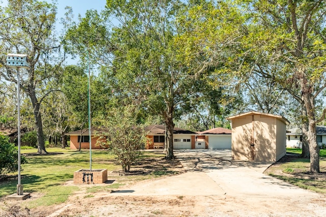 view of front of home with a front yard, a garage, and an outdoor structure