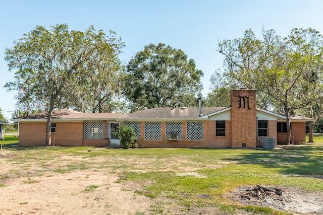 rear view of property with a yard and central air condition unit