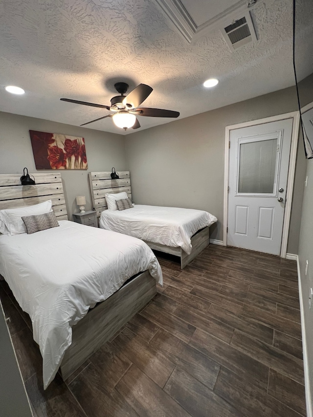 bedroom featuring ceiling fan, a textured ceiling, and dark hardwood / wood-style flooring