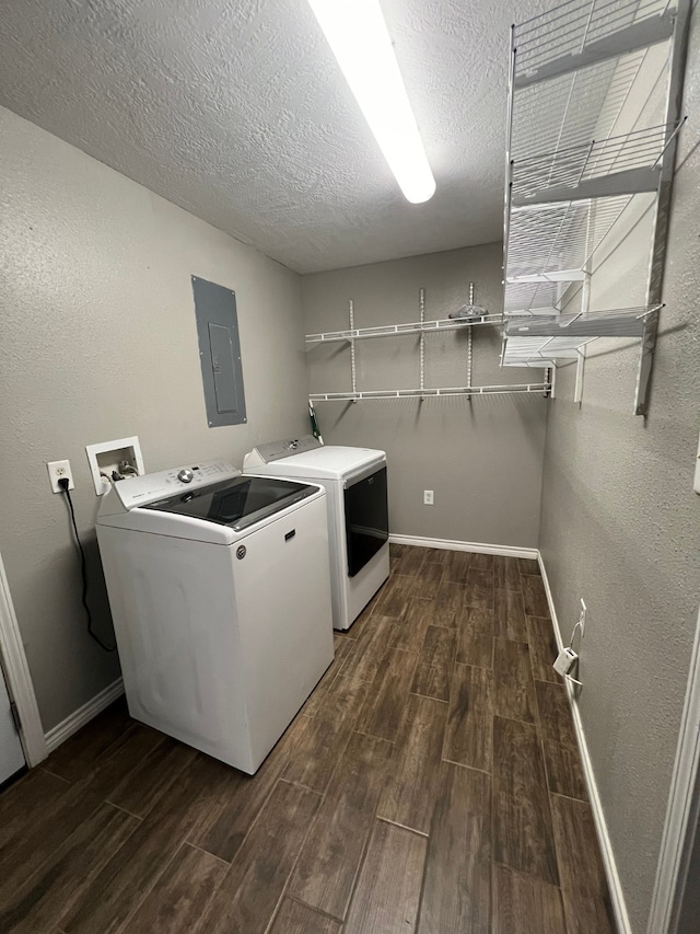 laundry room with washing machine and dryer, electric panel, a textured ceiling, and dark hardwood / wood-style flooring