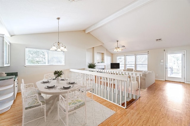 dining area with lofted ceiling with beams, light wood-type flooring, and ceiling fan with notable chandelier