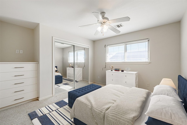 carpeted bedroom featuring ceiling fan and a closet