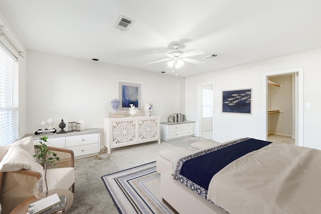 bedroom featuring ensuite bath, ceiling fan, a spacious closet, light colored carpet, and a closet