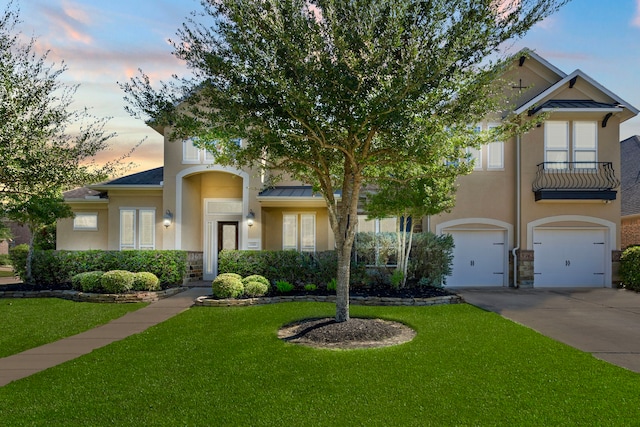 view of front of home featuring a garage, concrete driveway, a lawn, and stucco siding