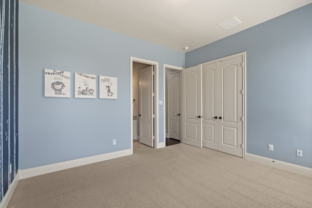 unfurnished bedroom with a closet and light colored carpet