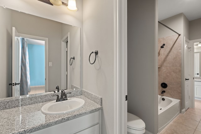 full bathroom with vanity, tiled shower / bath combo, toilet, and tile patterned flooring