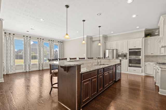 kitchen with a kitchen breakfast bar, stainless steel appliances, sink, and a large island