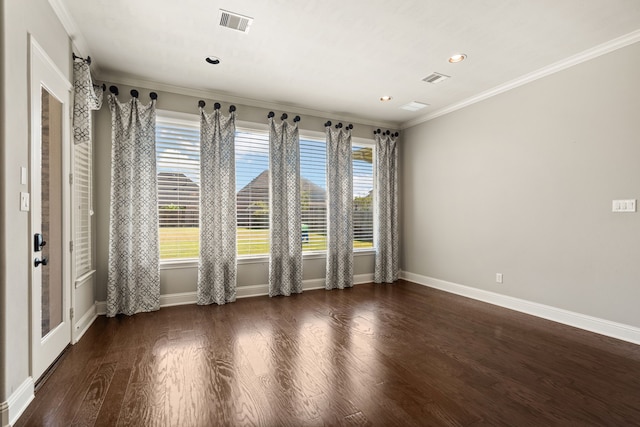 unfurnished room featuring dark wood-type flooring, crown molding, and plenty of natural light