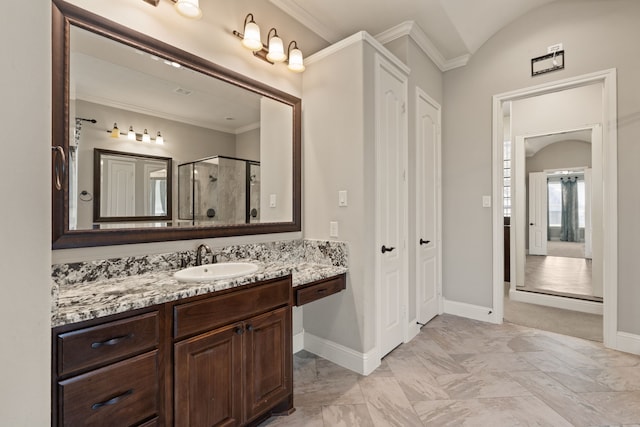 bathroom with vanity, a shower with shower door, and ornamental molding