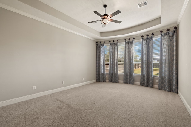 unfurnished room with ceiling fan, carpet flooring, a tray ceiling, and ornamental molding