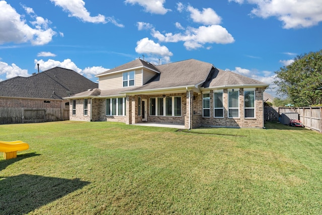 rear view of property with a lawn