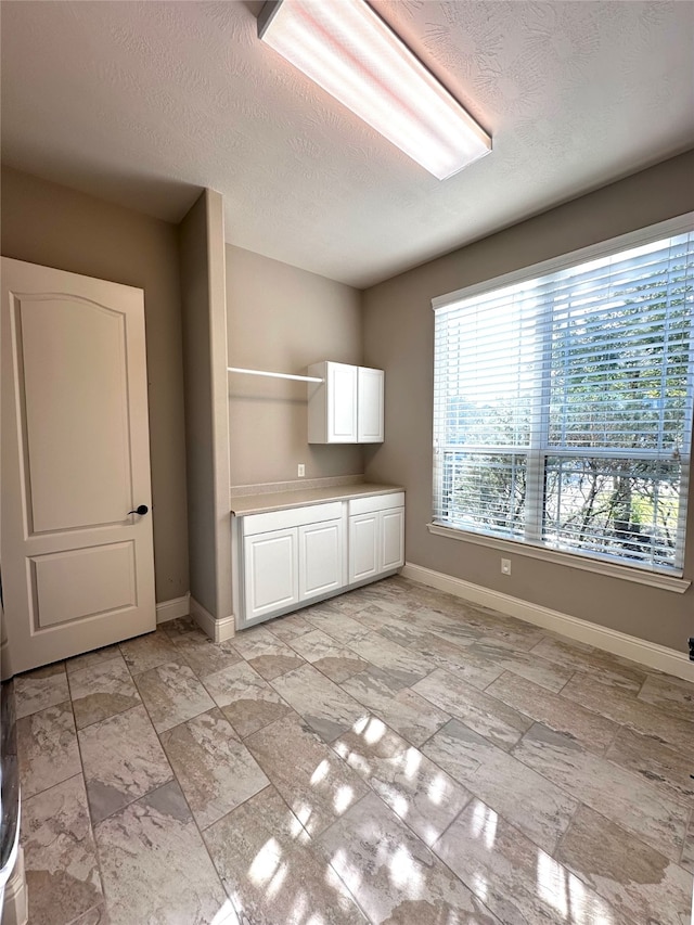 interior space featuring white cabinets and a textured ceiling