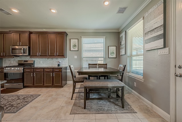 dining area with light tile patterned flooring and ornamental molding