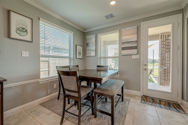 dining area featuring plenty of natural light, light tile patterned floors, and crown molding