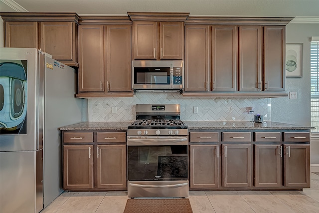 kitchen featuring light tile patterned floors, light stone countertops, and stainless steel appliances