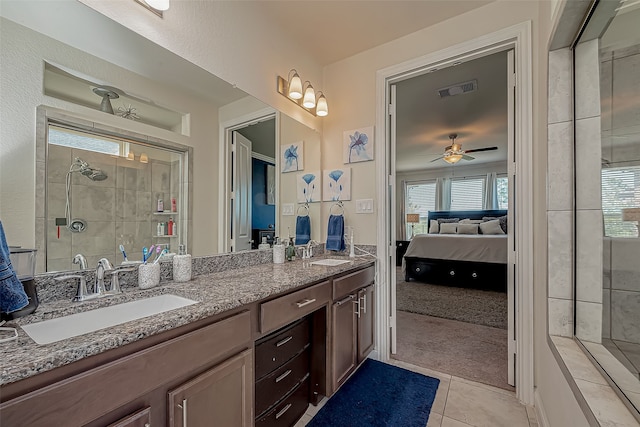 bathroom with ceiling fan, vanity, a tile shower, and a wealth of natural light