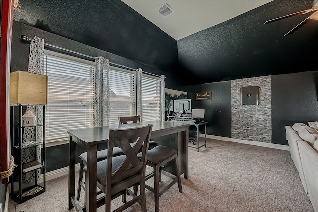 dining area with ceiling fan, carpet floors, and a textured ceiling