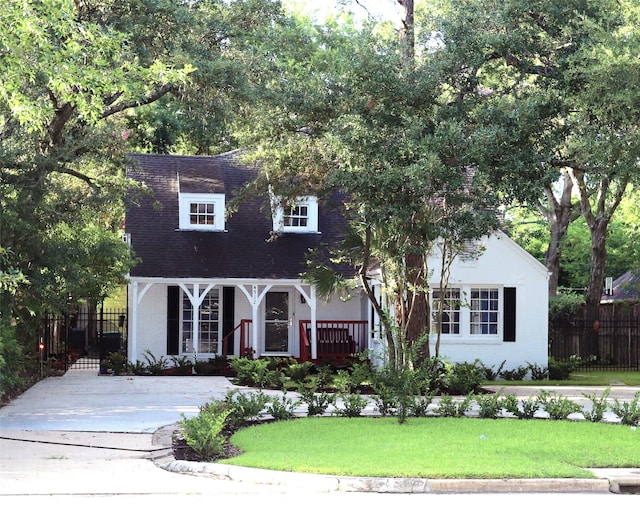 cape cod house featuring a front lawn and a porch