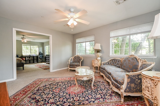 living room featuring ceiling fan and a healthy amount of sunlight