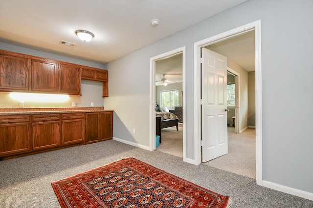 kitchen with light carpet and ceiling fan