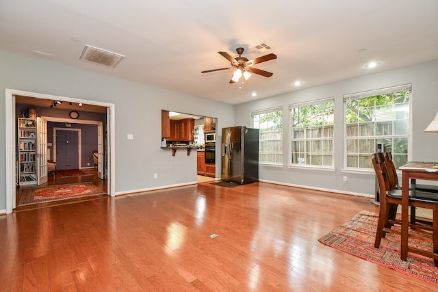 living room with light wood-type flooring and ceiling fan