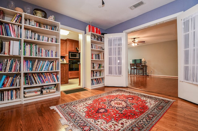 living area with ceiling fan and light hardwood / wood-style flooring