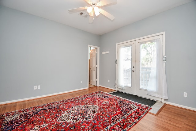 entryway with hardwood / wood-style flooring, ceiling fan, and french doors