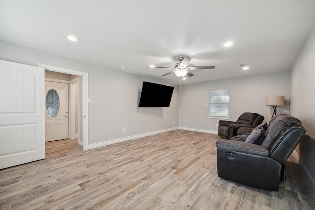 living room with light hardwood / wood-style floors and ceiling fan