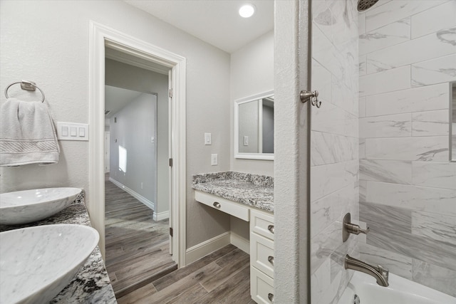 bathroom with plus walk in shower, hardwood / wood-style flooring, and vanity