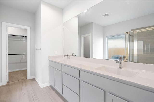 bathroom with vanity and a shower with shower door