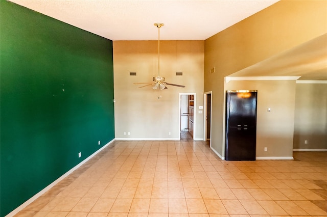 unfurnished room with crown molding, a high ceiling, and ceiling fan