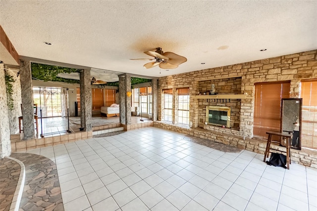 unfurnished living room with ceiling fan, a textured ceiling, and a healthy amount of sunlight